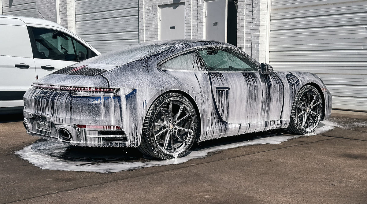 Porsche sports car covered in foam during an exterior wash at Martin Auto Detailing in Dallas.